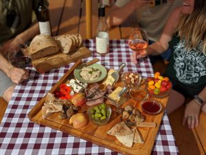 Cheese and charcuterie platter on a picnic table.